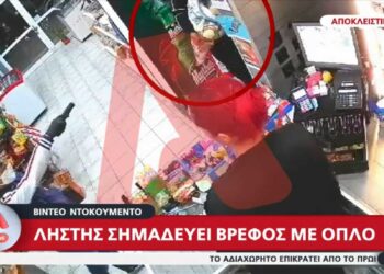Βίντεο με τον Ληστή να σημαδεύει μωρό σε μίνι μάρκετ για να πάρει τα χρήματα από το ταμείο (video)