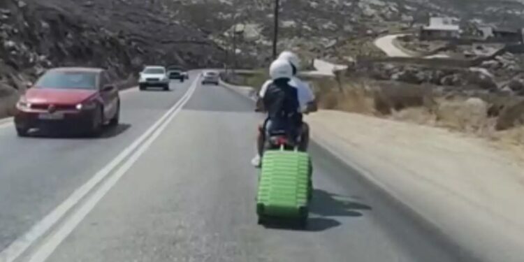 Το είδαμε και αυτό στη Μύκονο: Εκείνος στο τιμόνι του σκούτερ κι εκείνη να τσουλάει τη βαλίτσα στον δρόμο[video]