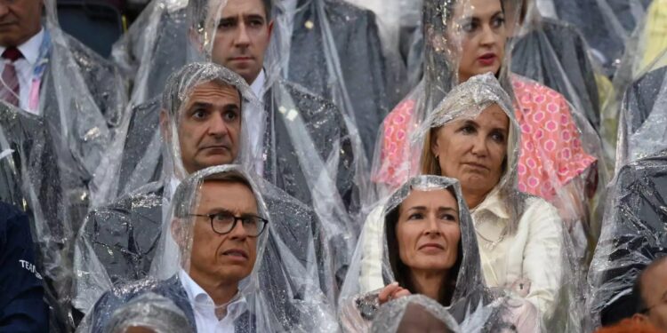 Ο Κυριάκος Μητσοτάκης και η Μαρέβα στην τελετή έναρξης των Ολυμπιακών Αγώνων με νάιλον λόγω της βροχής