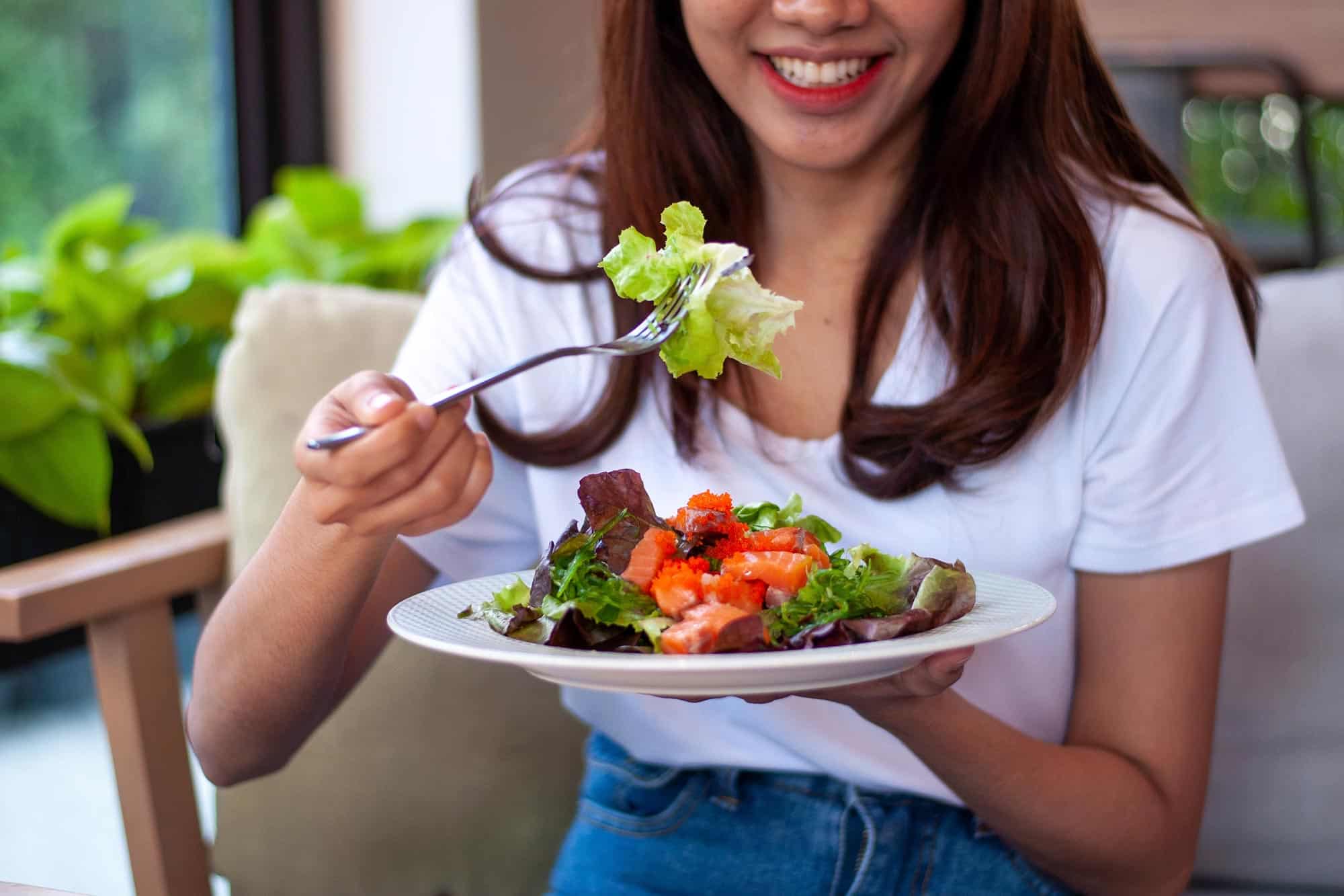young woman eating salad
